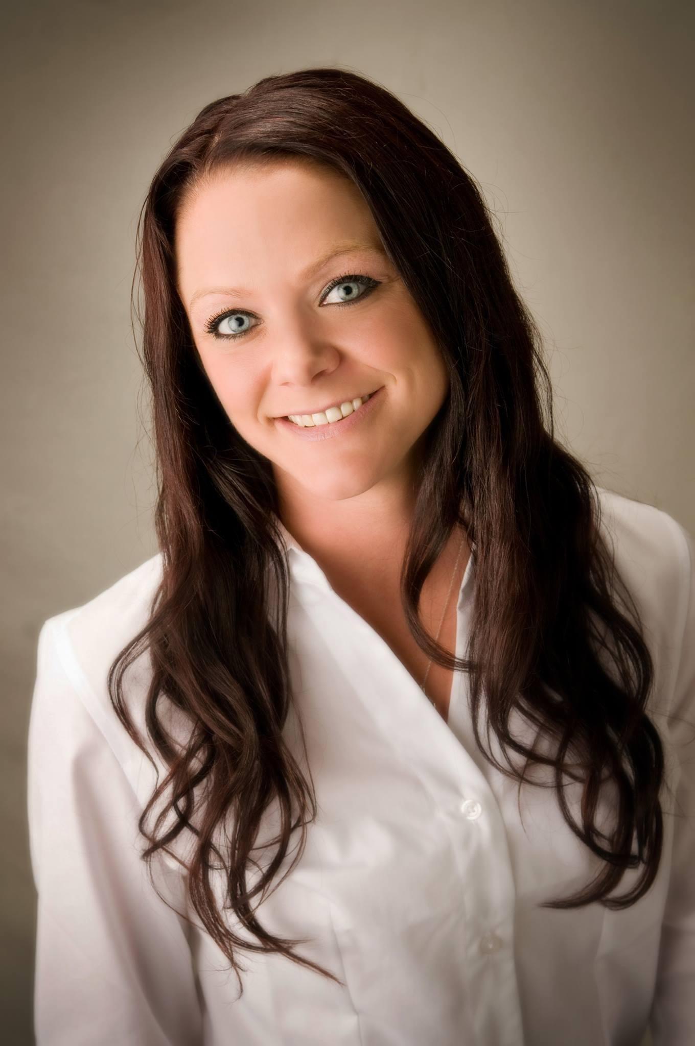 Anne Corinne Huggins-Manley with long hair smiling