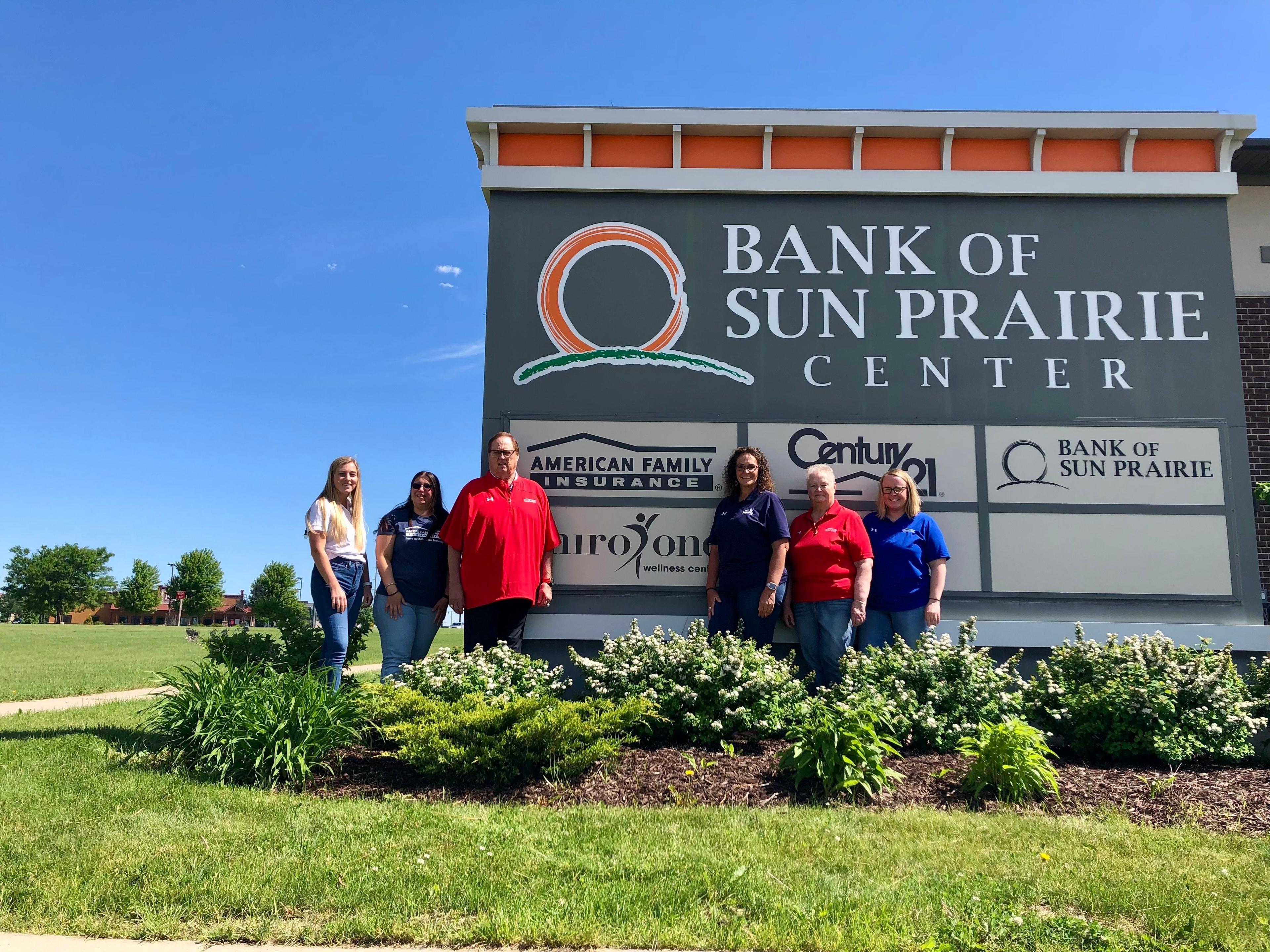 a group of people standing in front of a sign