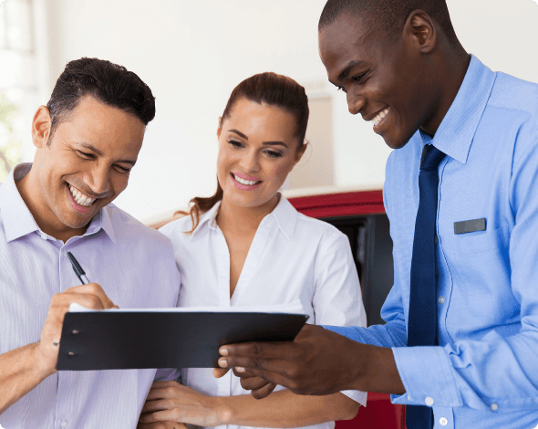 A man signing on a document to buy a car