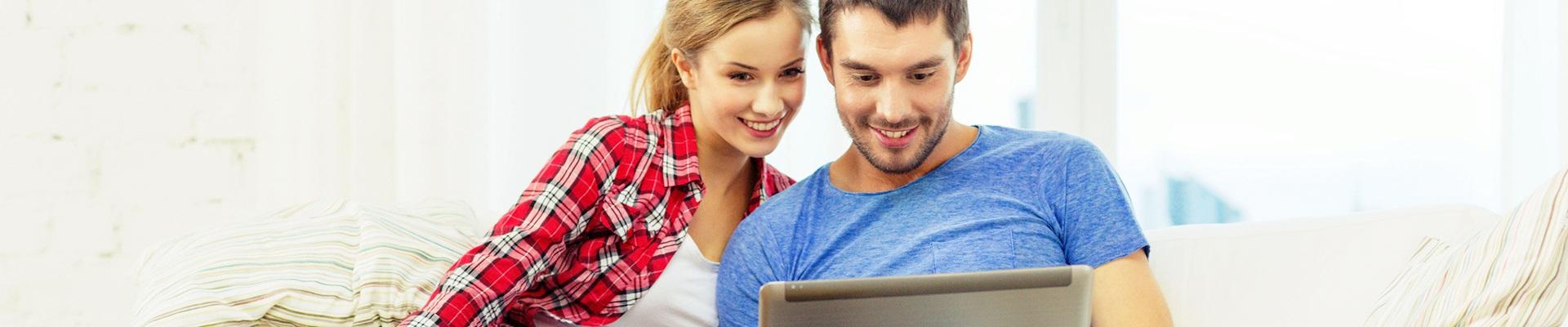 a man and a woman looking at a laptop