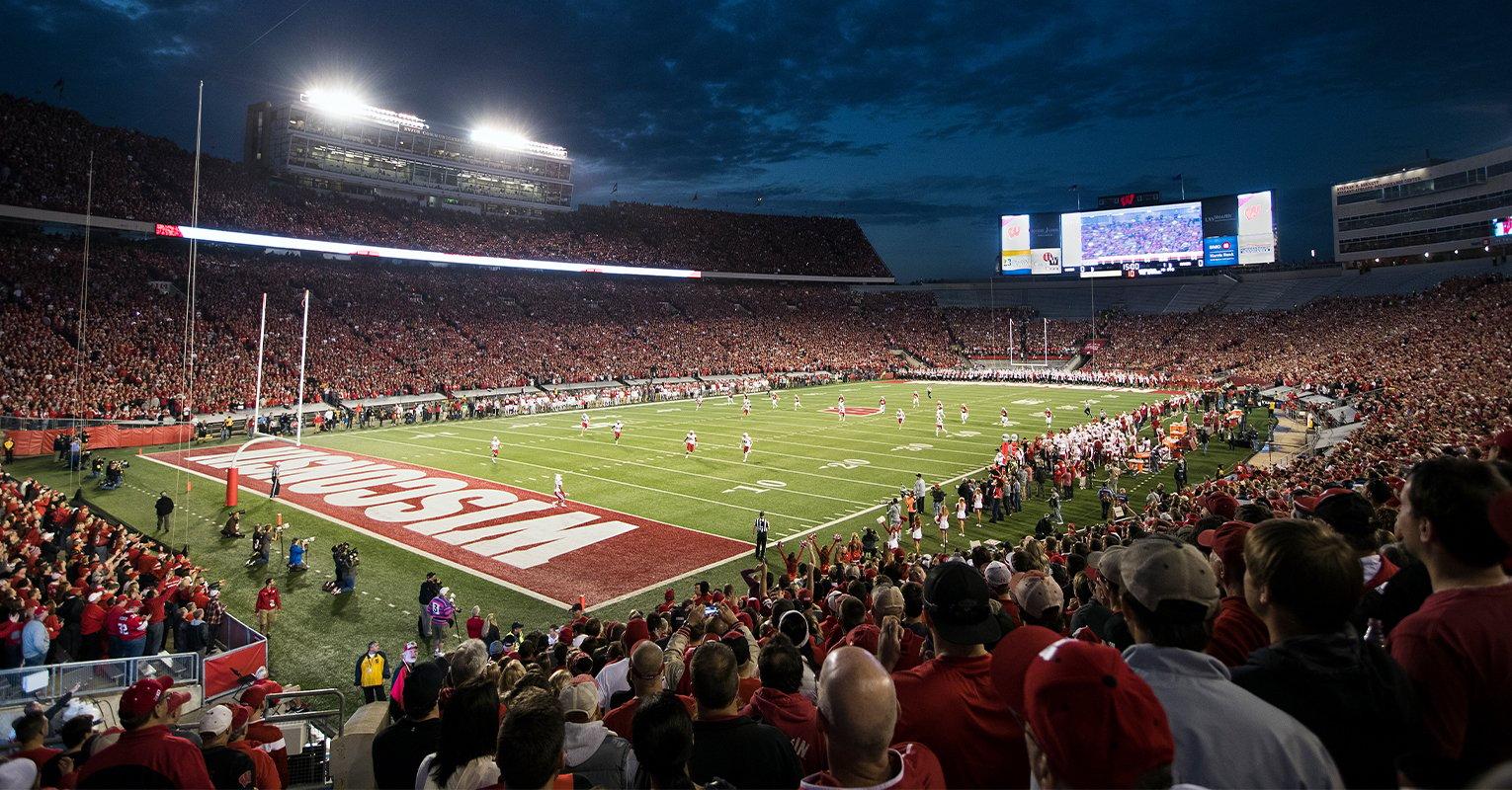 a sports stadium with a field and a crowd of people