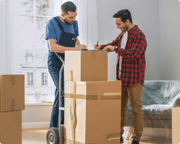 a man signing something for a male mover over boxes