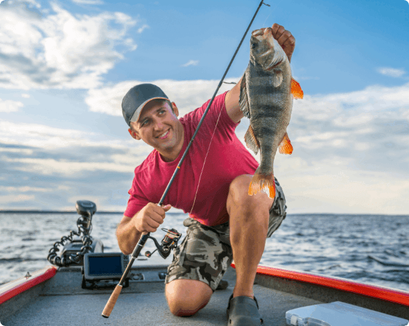 A person on a fishing boat holding up a large fish. 