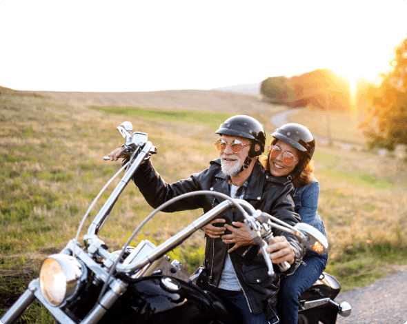 A couple going for a motorcycle drive on a sunny day. 