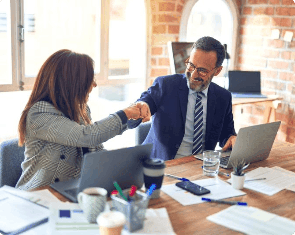 Two co-workers celebrating with a fist bump.