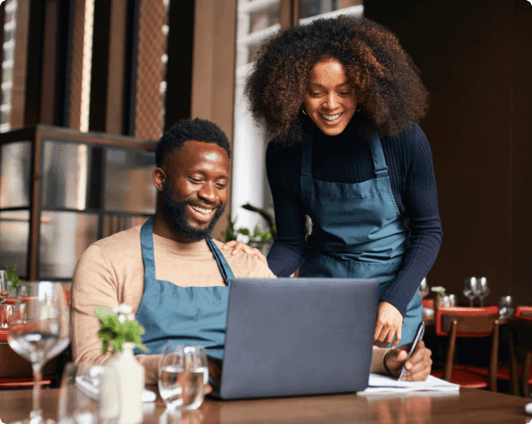 Two business owners looking at a laptop. 