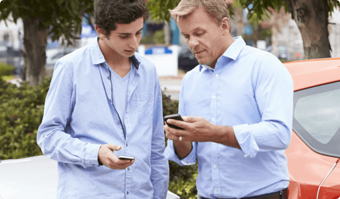 two men looking at a phone