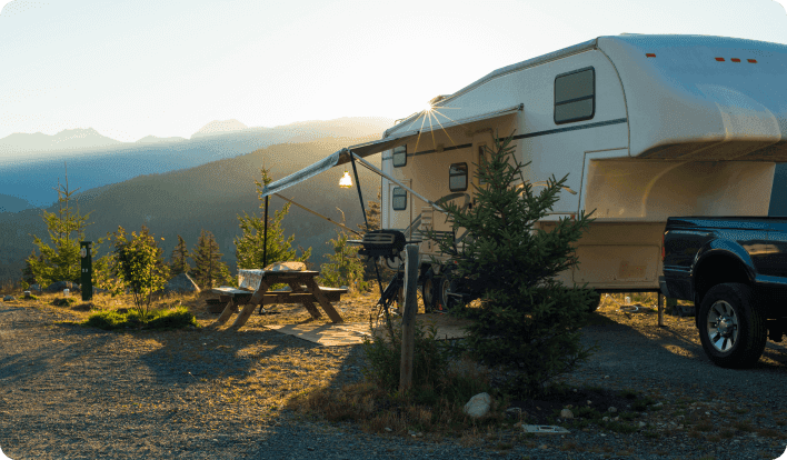 a trailer parked next to a tree